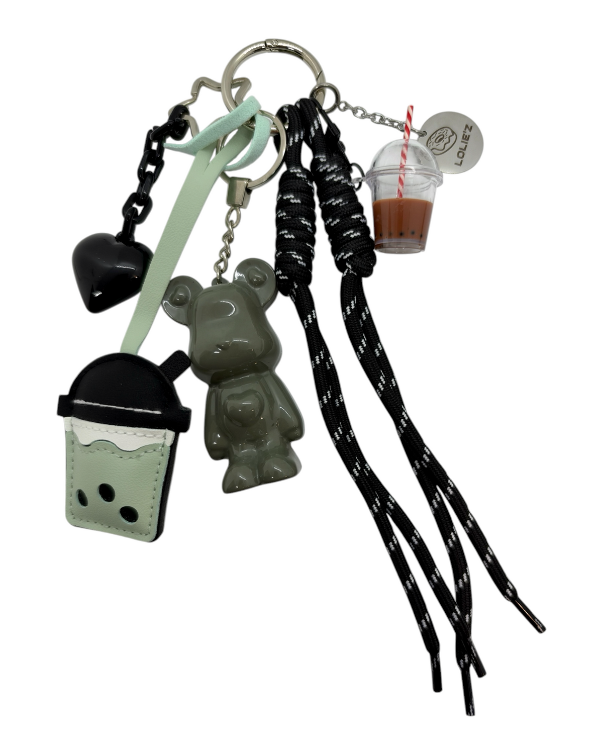 Vue détaillée du grigri Marley Bubble Trouble sur fond blanc, composé d'un ourson kaki glossy, d'un cœur noir, de deux gobelets bubble tea, de cordons noirs et d'une médaille Lolie'z.