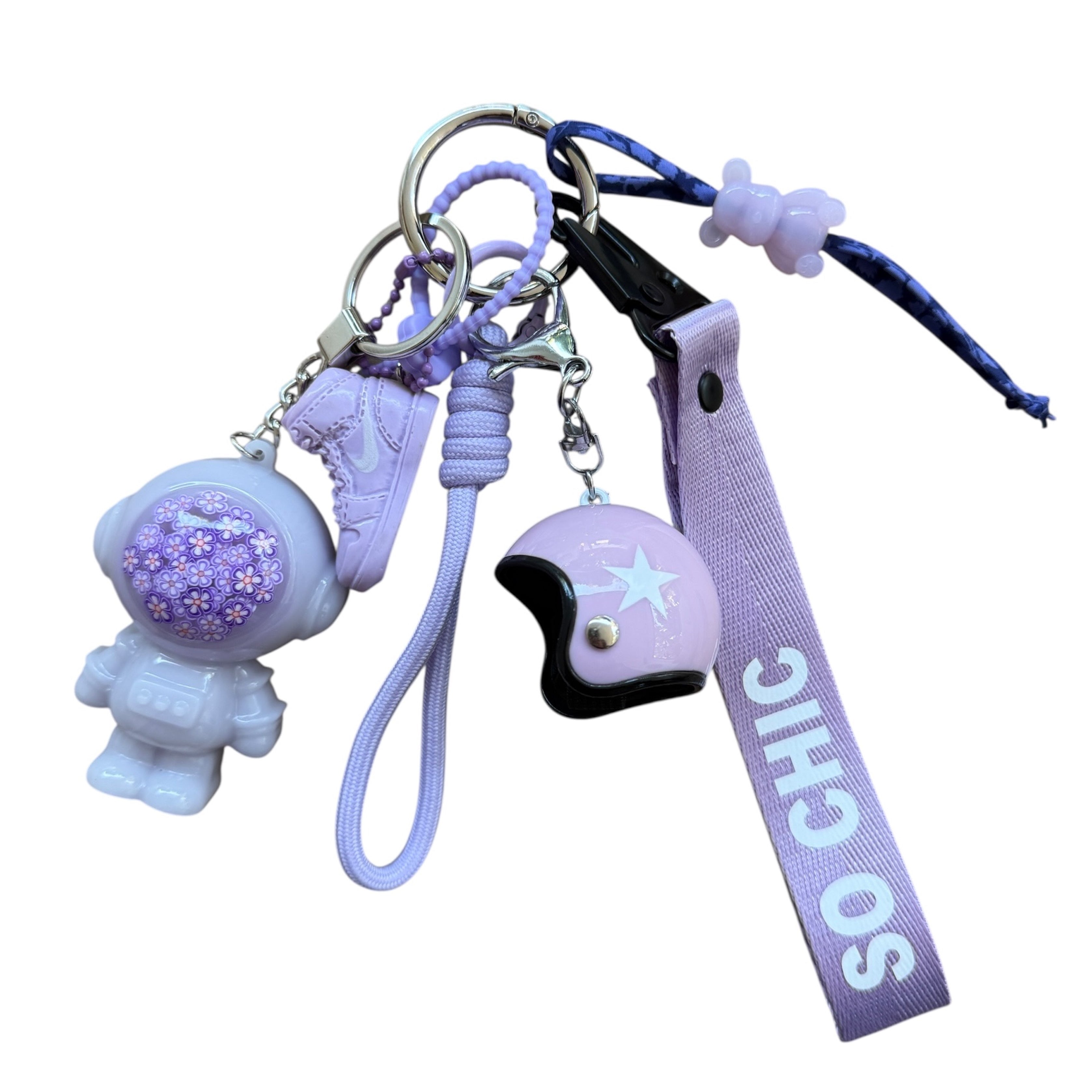 Andy Lilac Society, grigri de sac astronaute lilas en résine époxy avec détails floraux violets.