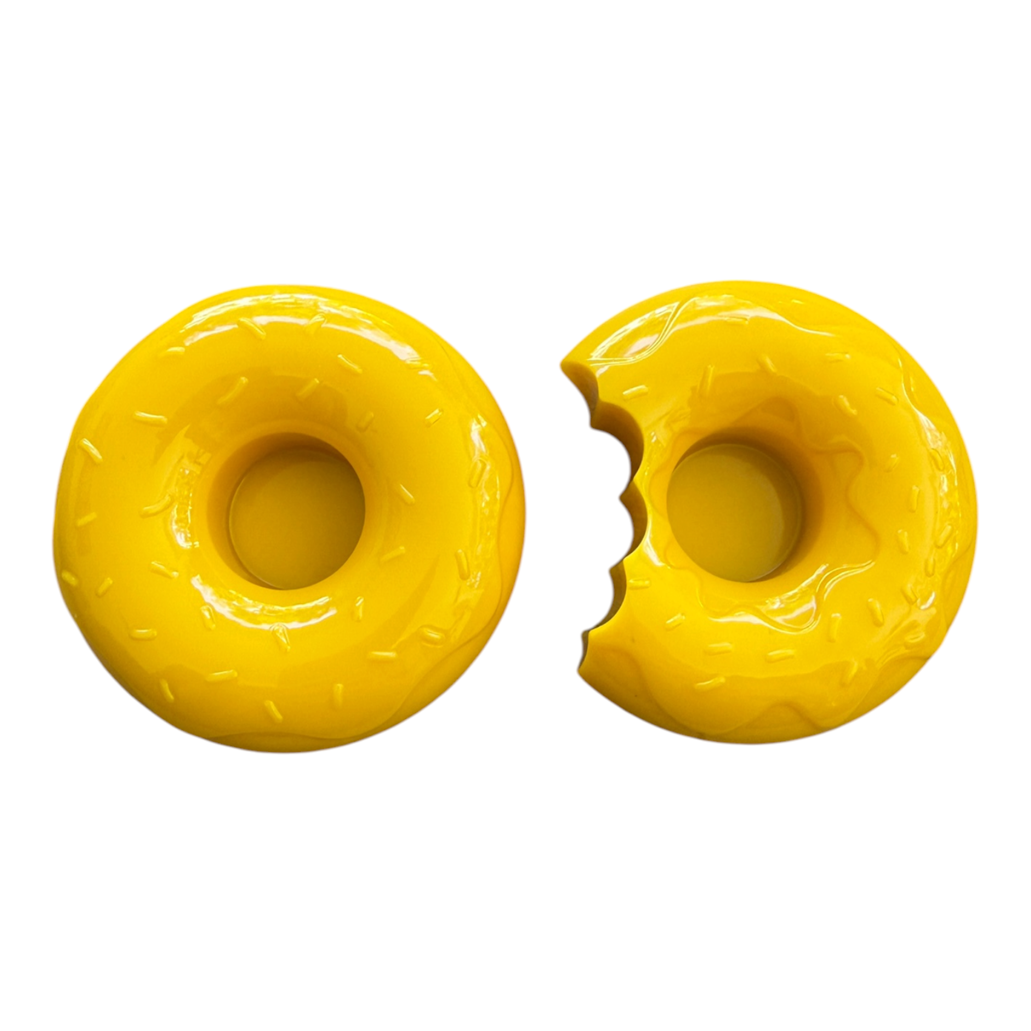 Deux bougeoirs décoratifs en forme de donuts, dans des tons rose et jaune doux, apportant une touche joyeuse et colorée à la décoration intérieure.
