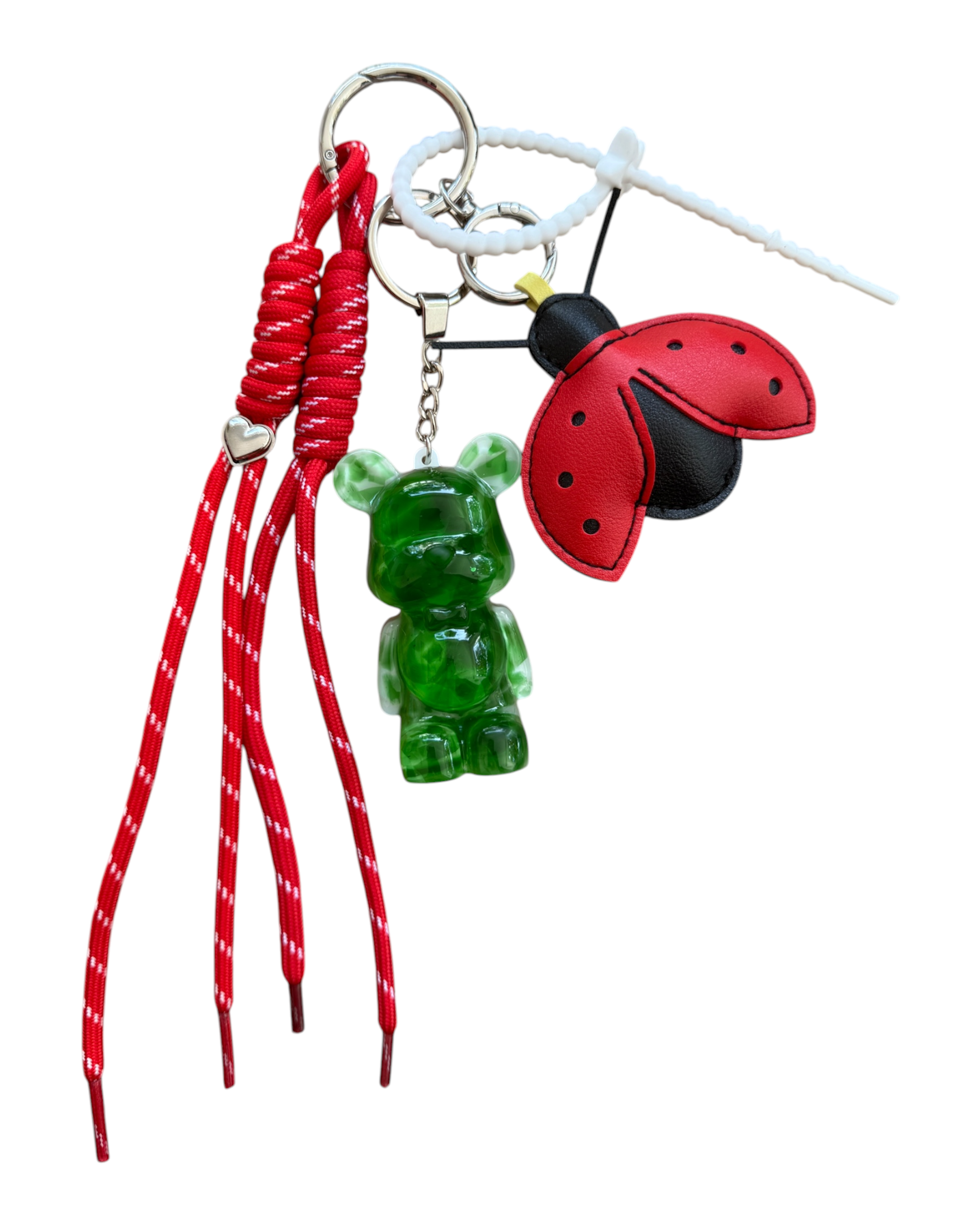 Grigri Lady Green avec Teddy'z vert translucide en résine époxy, coccinelle rouge et cordon rouge.
