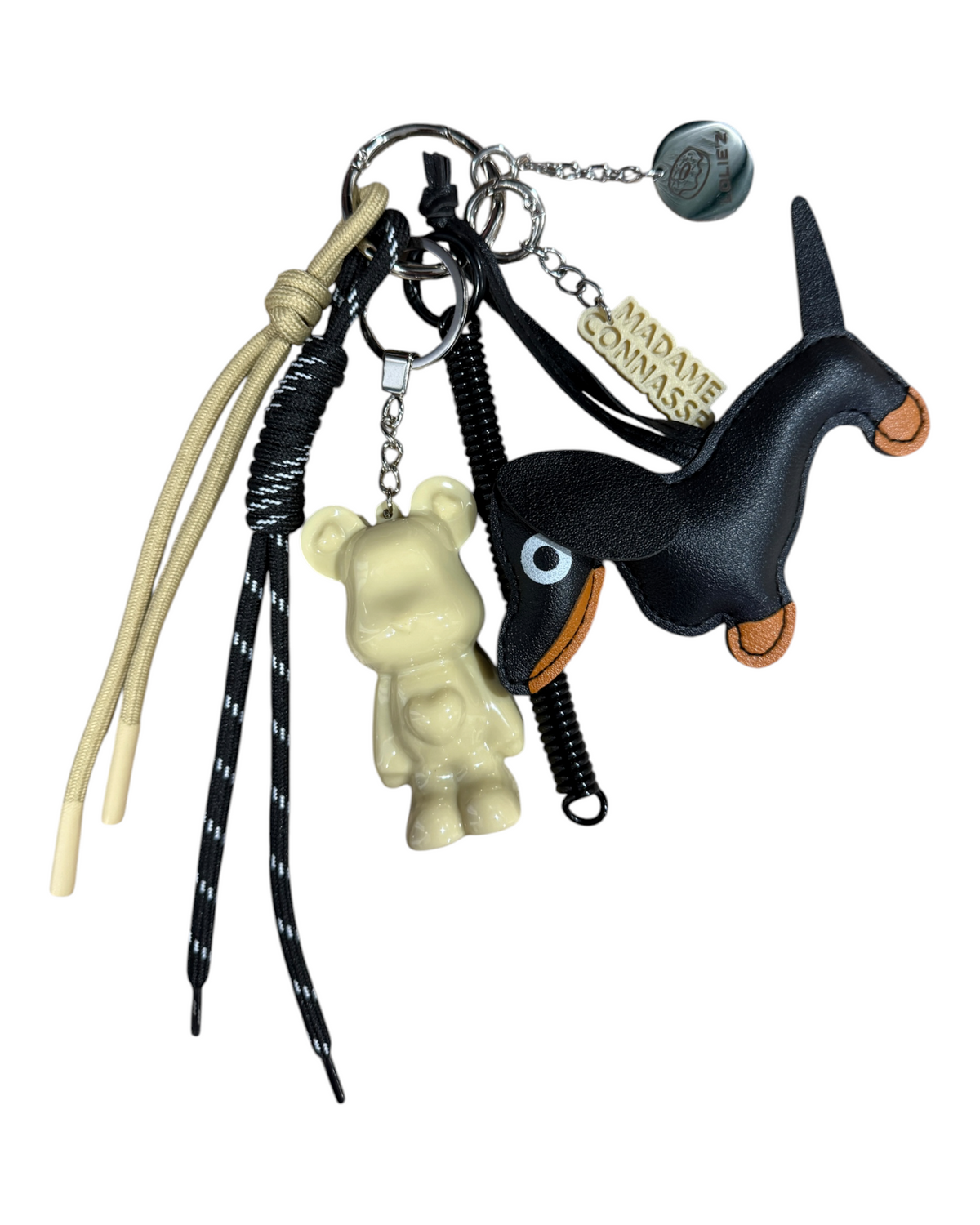 Marley Trouble Maker, grigri de sac fait main avec Marley crème, chien noir, cordons noir et beige et médaille gravée Lolie’z.