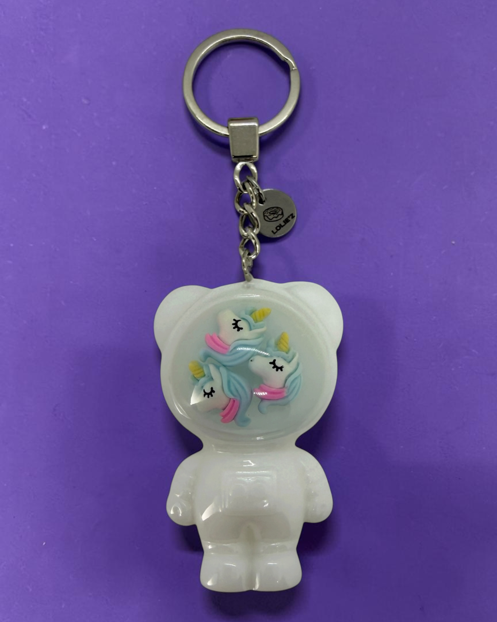 Izzy Cloudy Dream, porte-clés Astro Bear blanc en résine époxy fait main avec trois petites licornes aux détails pastel.