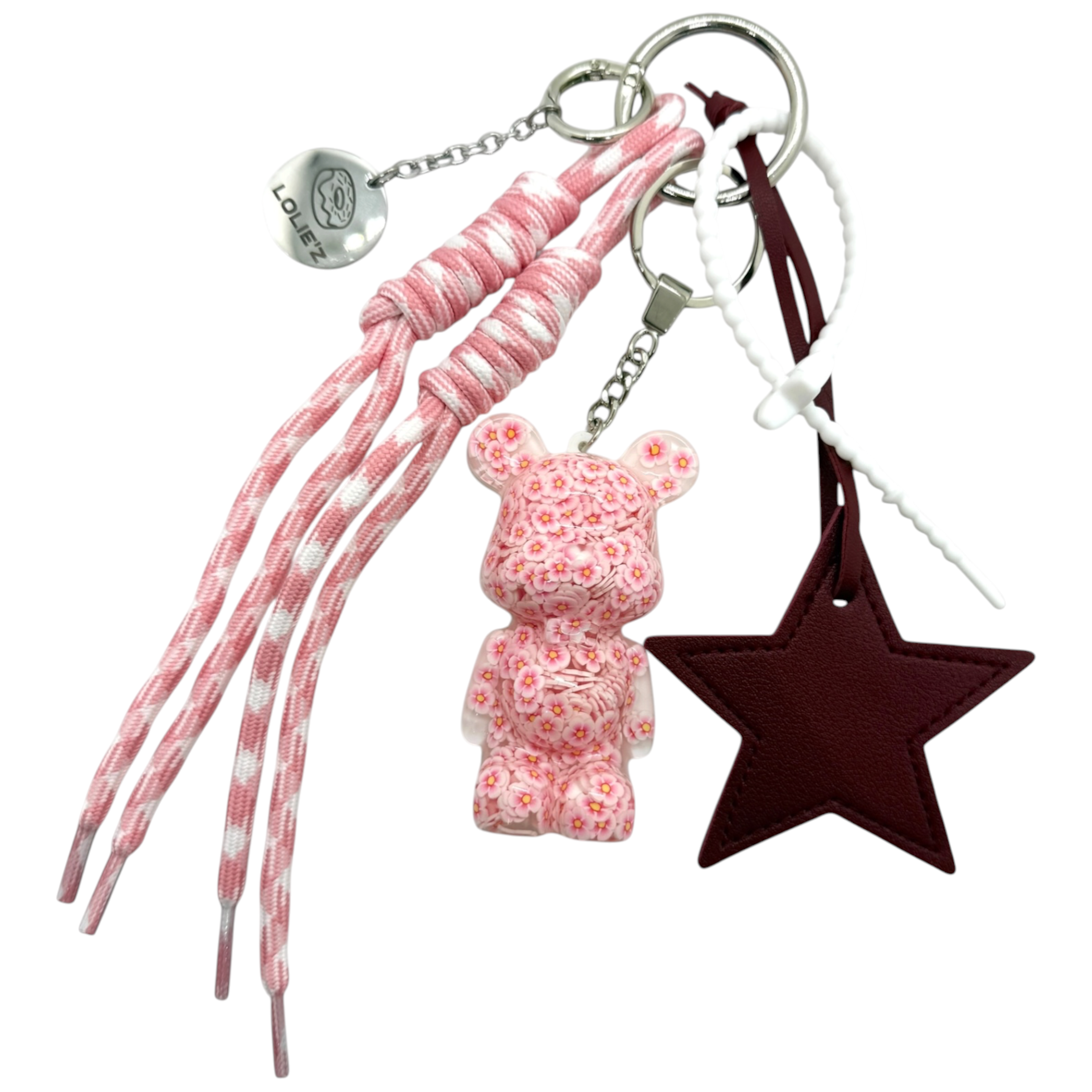 Grigri Lucky Star avec Teddy’z en résine époxy recouvert de petites fleurs roses, grande étoile bordeaux et cordons rose poudré et bordeaux.