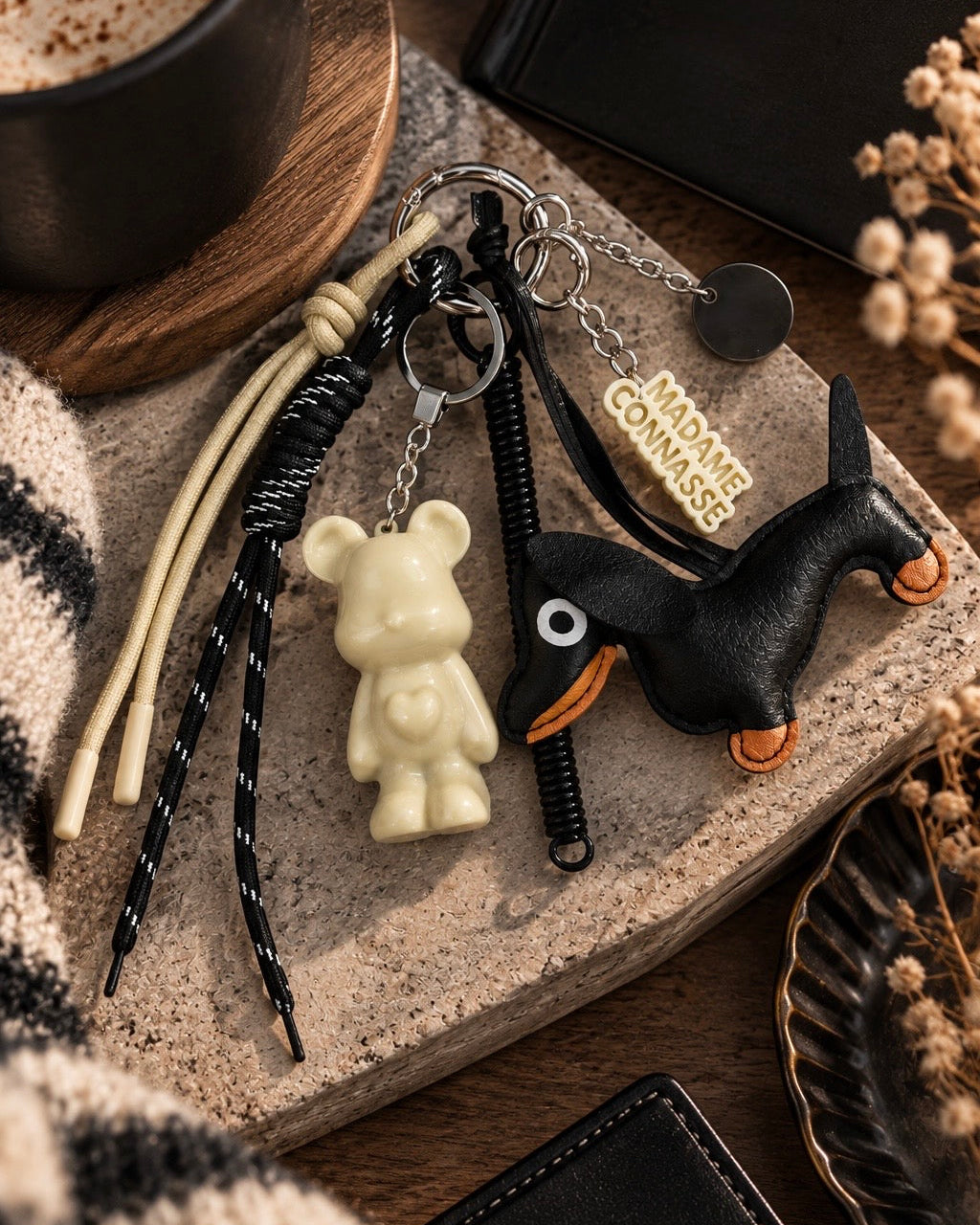 Grigri de sac Marley Trouble Maker avec Marley crème glossy, chien noir et longs cordons noir et beige, création artisanale Lolie’z.