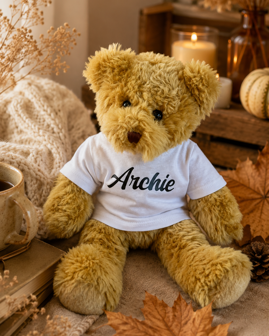 Ours en peluche Archie avec t-shirt blanc personnalisé, présenté dans une ambiance automnale cosy par Lolie’z en France.