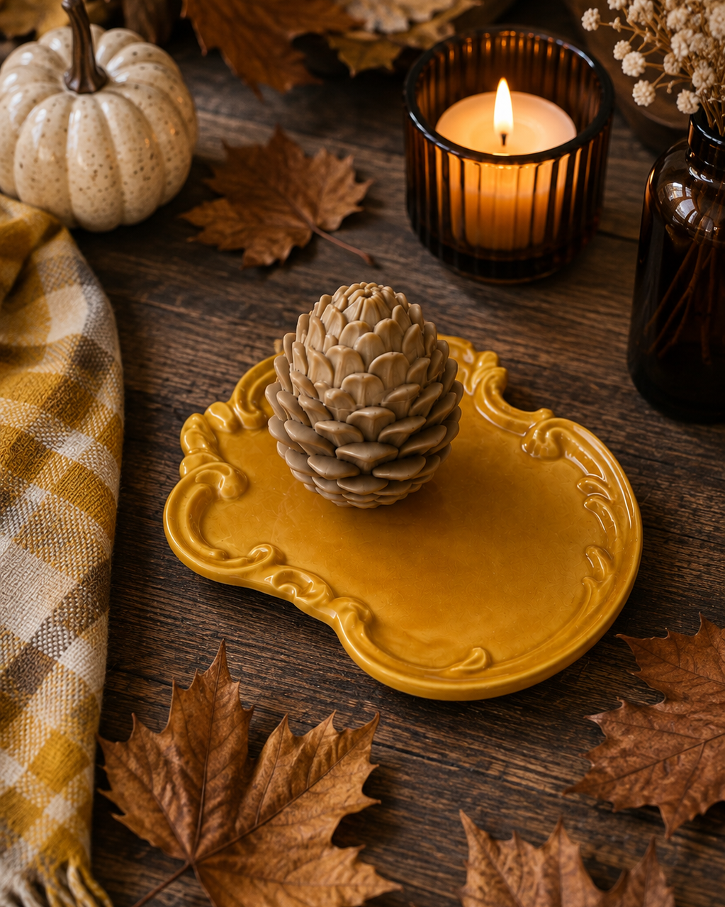 Plateau Rococo doré en résine époxy fait main, présenté dans une décoration automnale avec pomme de pin, bougie et feuilles séchées.