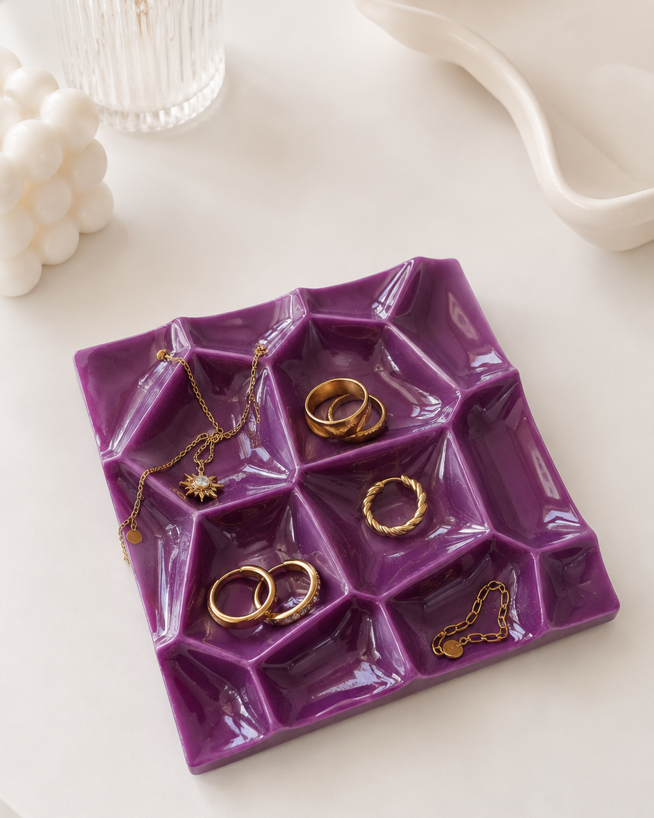 Porte-bijoux BLOOM violet prune en résine époxy posé sur une coiffeuse blanche avec bijoux dorés.