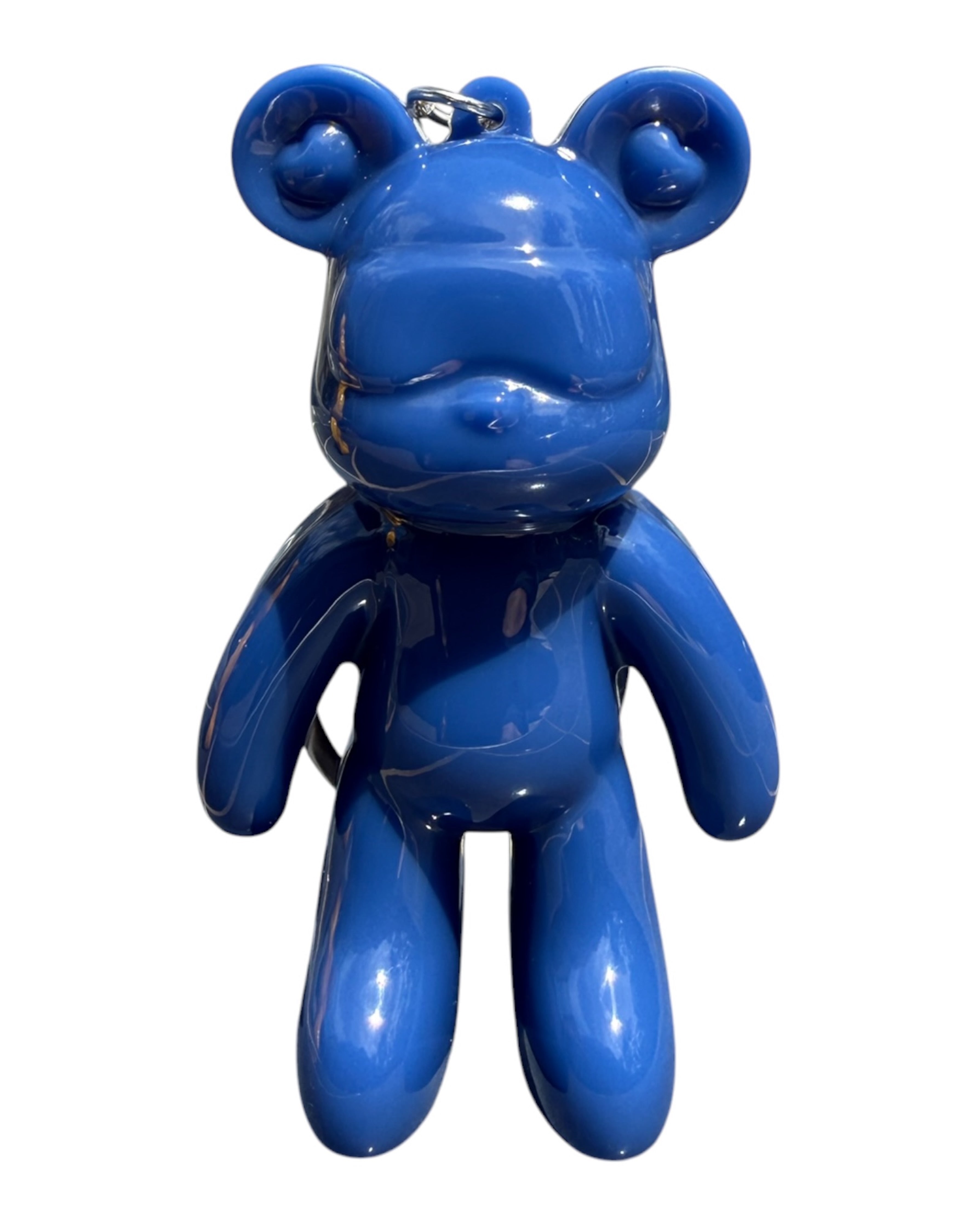 Petit ours bleu en résine époxy brillante utilisé comme accessoire tendance sur fond coloré et moderne.