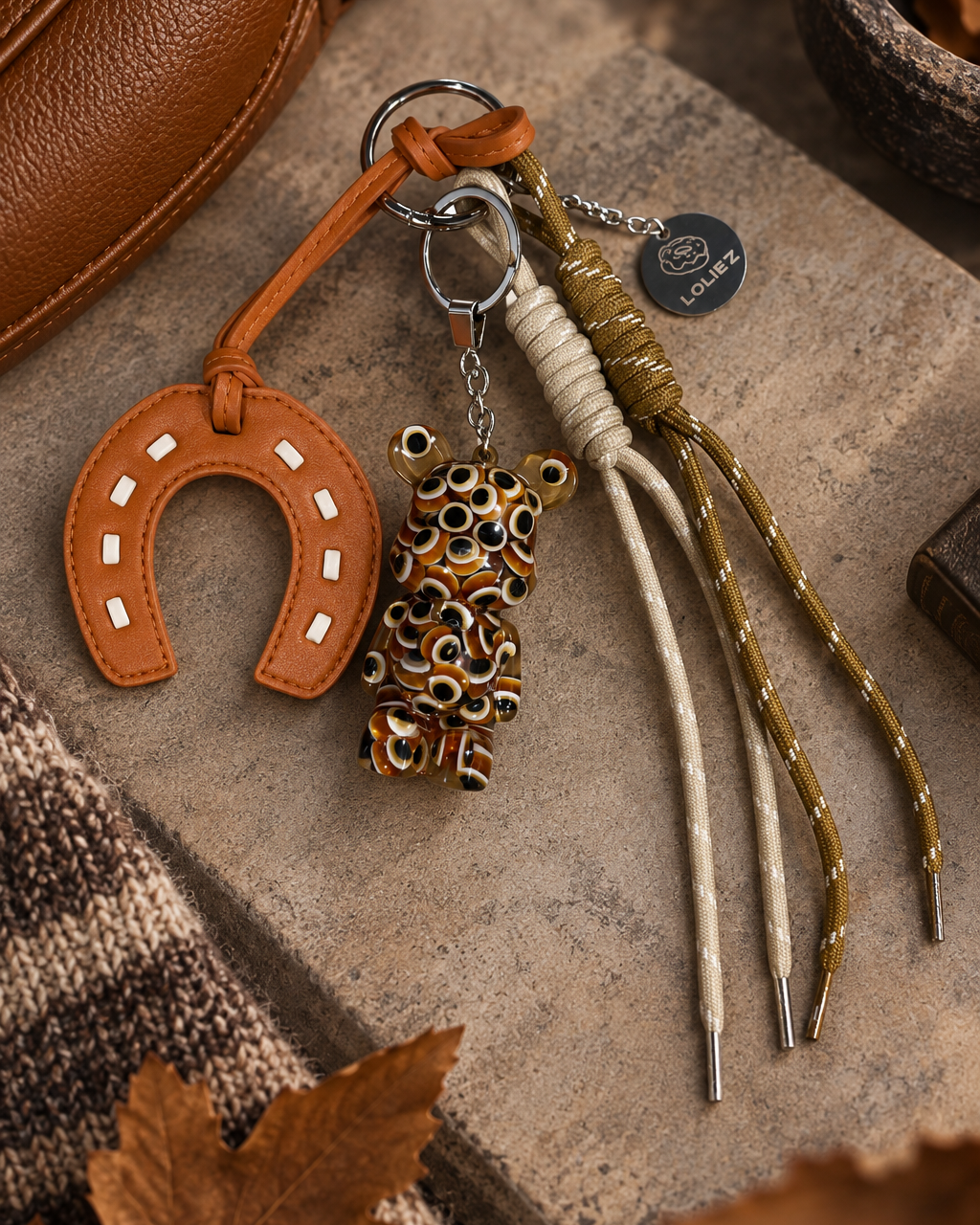 Grigri de sac Teddy’z Lucky Eyes avec ours à motifs œil, fer à cheval camel et cordons crème et brun, création artisanale Lolie’z.