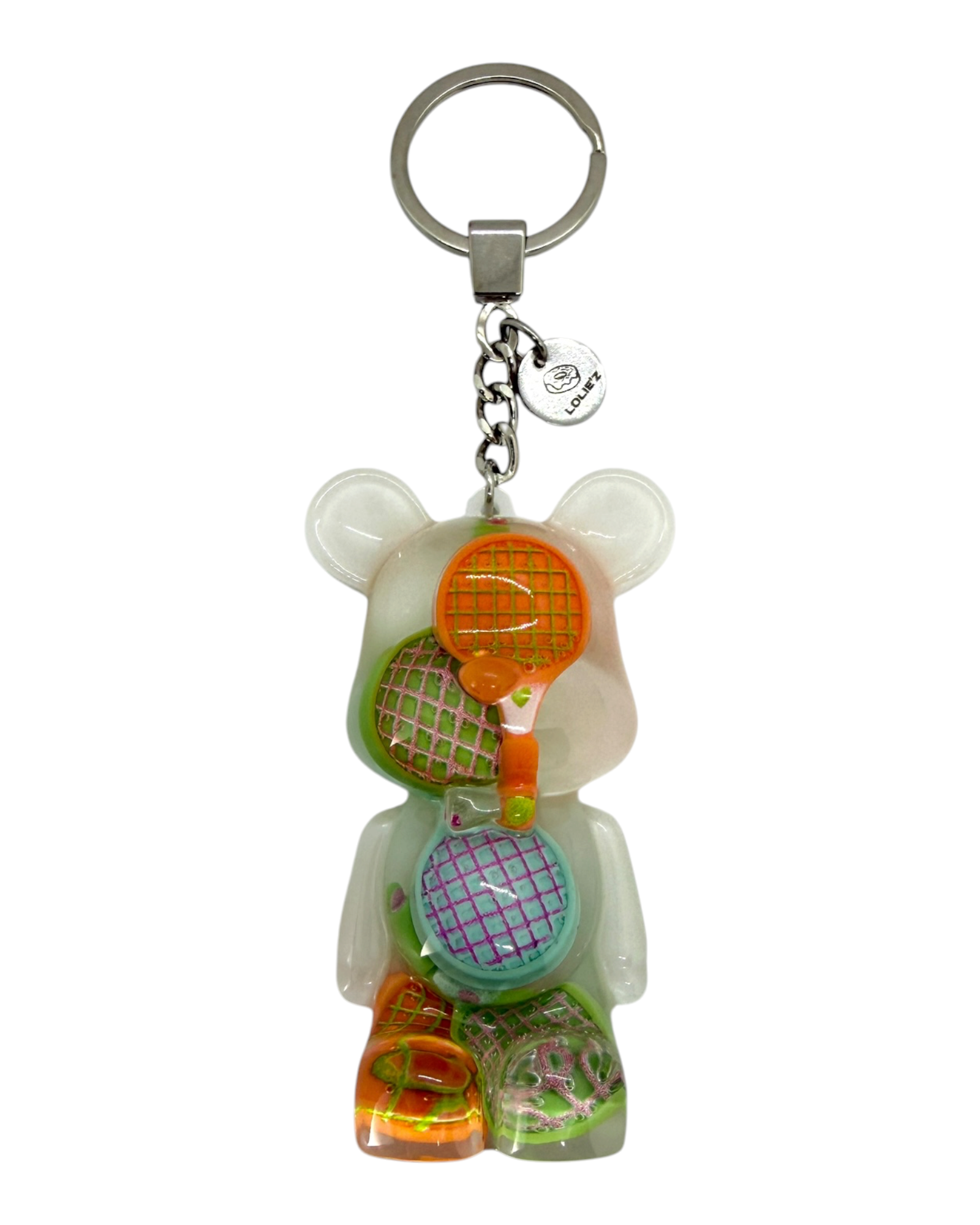 Porte-clés Teddy’z Match Point de Lolie’z, ours transparent décoré de raquettes de tennis multicolores avec médaille logo gravée.