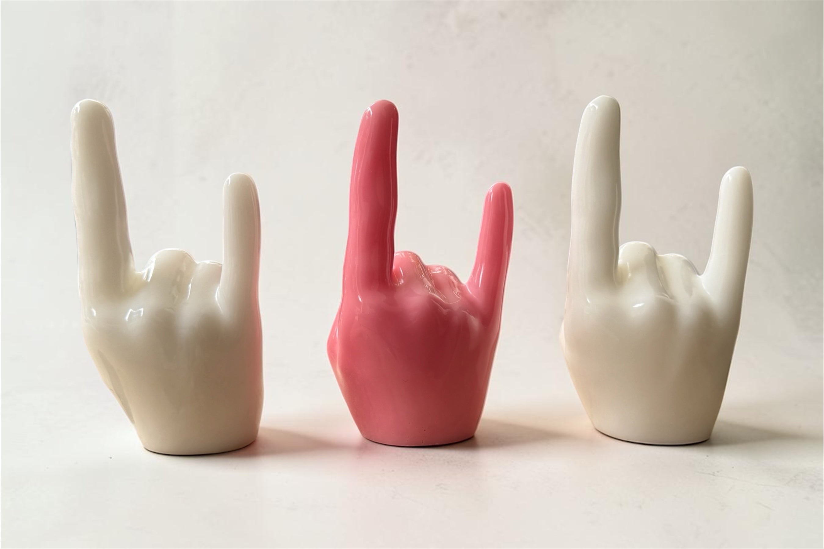 Objets décoratifs en résine époxy faits main, mains design en finition brillante avec une pièce centrale rose. Création artisanale moderne idéale pour une décoration intérieure originale et unique.