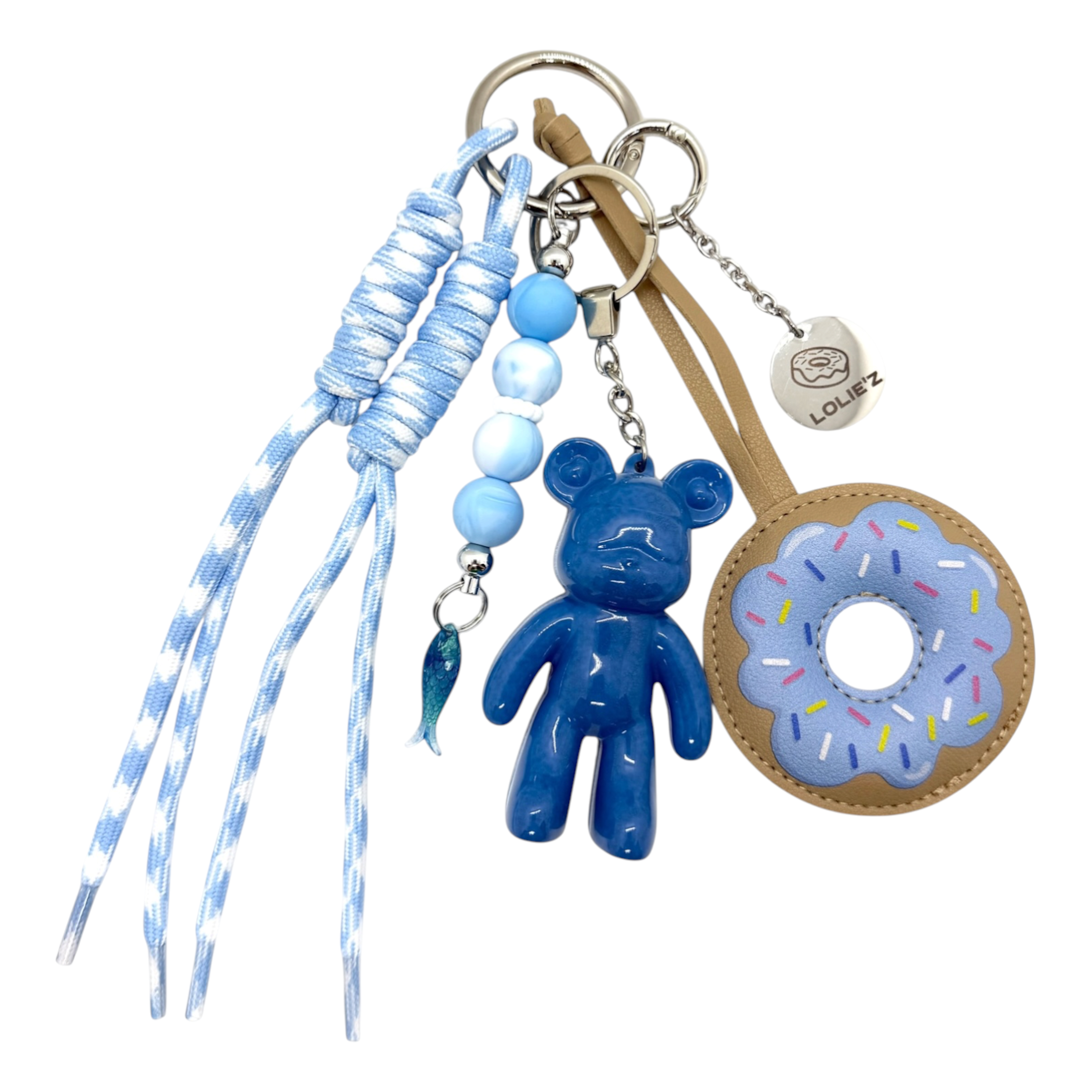 Grigri Blue Donut avec Teddy’z bleu en résine époxy, donut bleu ciel, cordons assortis, perles bleues et petit poisson.