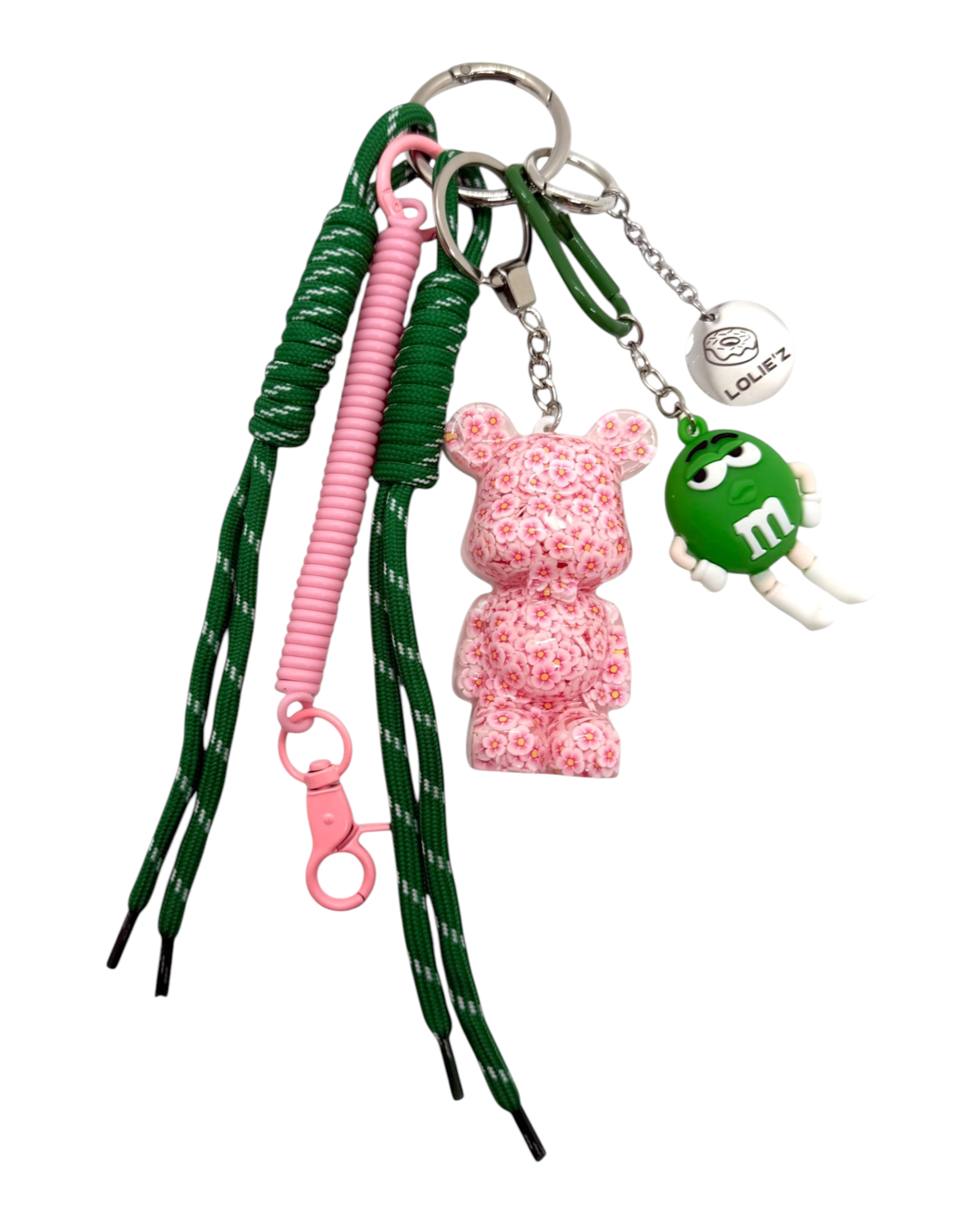 Grigri Flower Power avec Teddy’z en résine époxy recouvert de petites fleurs roses, cordons roses et verts et accessoires assortis.