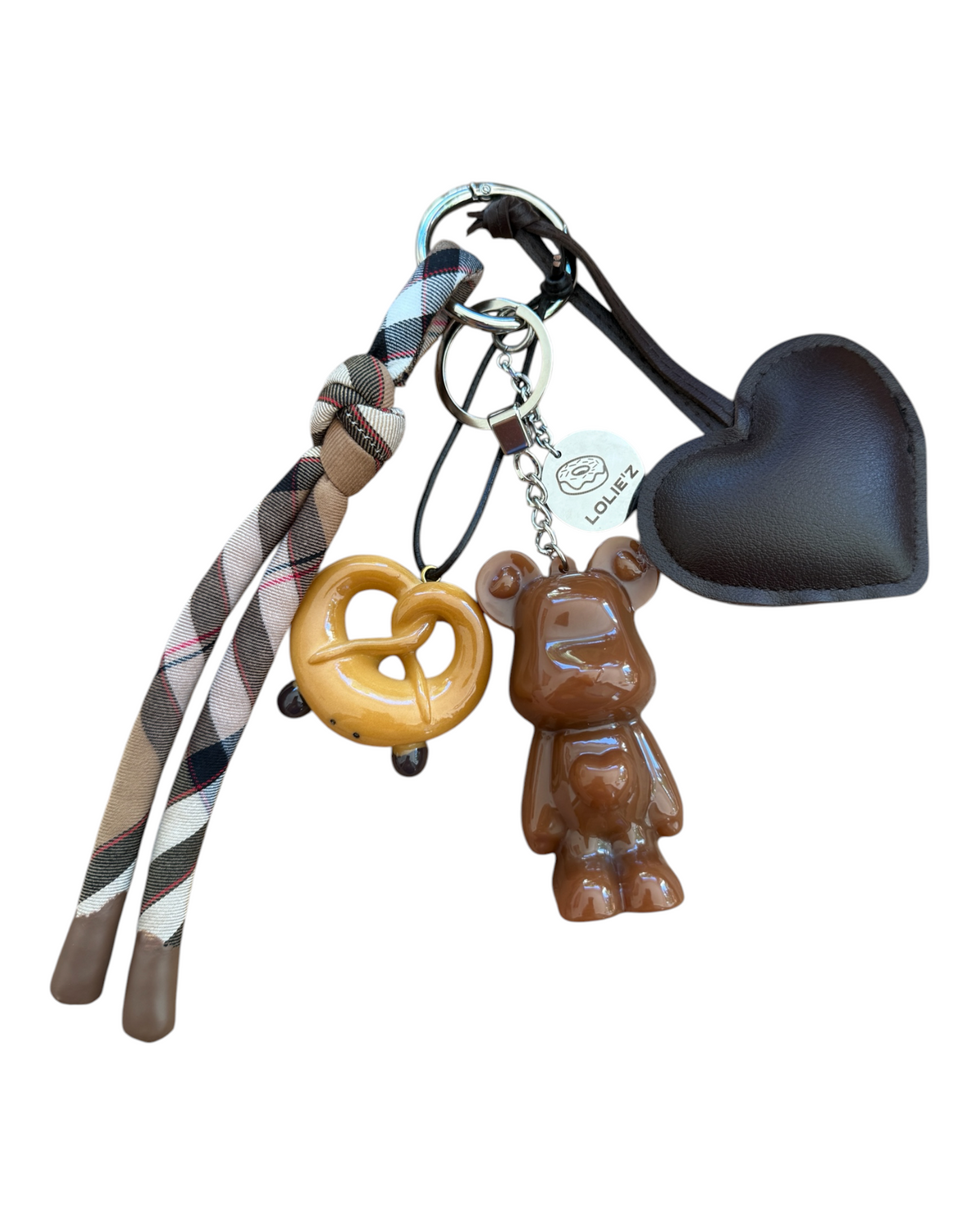 Grigri de sac Marley Crazy Pretzel en résine époxy avec breloque bretzel, cœur chocolat et long ruban à carreaux.