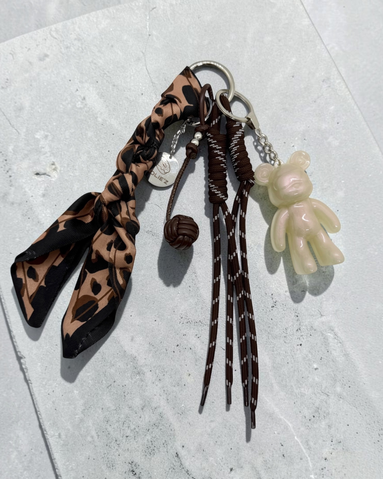 Grigri de sac Lolie’z avec Teddy’z nacré en résine époxy, foulard léopard, cordons marron et breloque chocolat, création assemblée à la main en France.