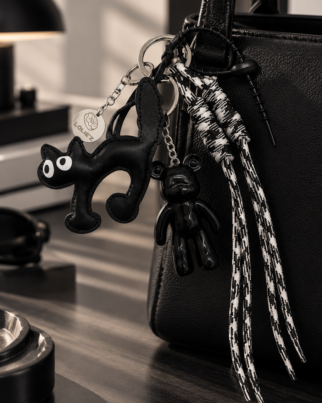 Grigri de sac Lolie’z noir et blanc avec Teddy’z en résine époxy, breloque chat noir, cordons imprimés et médaille gravée, assemblé à la main en France.