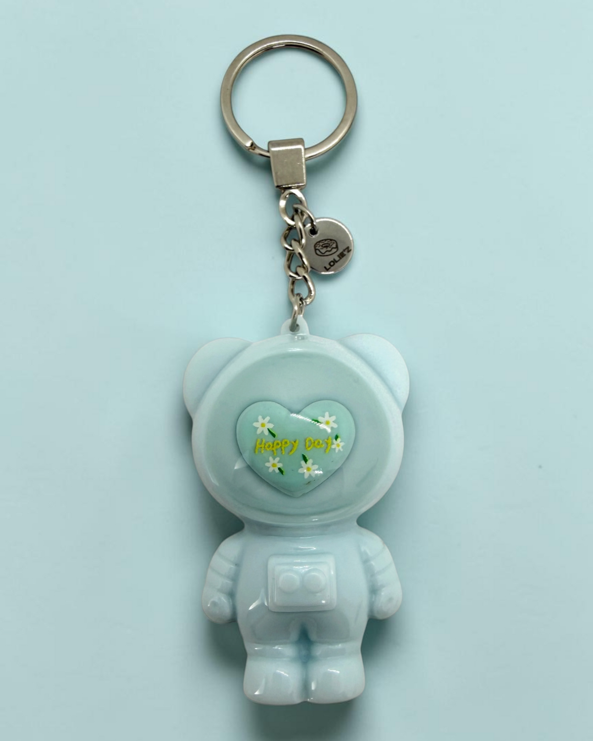 Izzy Happy Day, porte-clés Astro Bear en résine époxy fait main représentant un petit ours astronaute dans son casque.