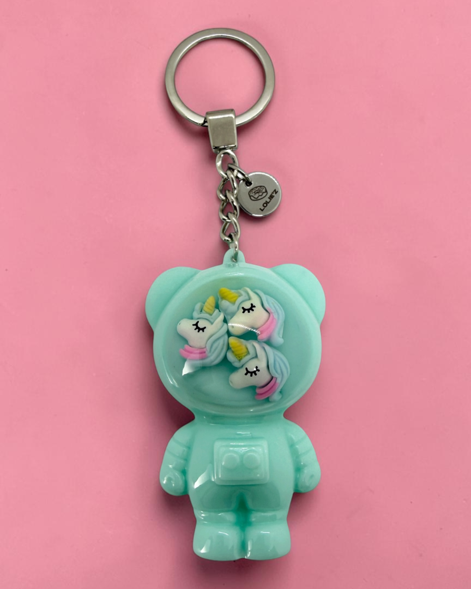 Izzy Minty Magic, porte-clés Astro Bear vert menthe en résine époxy avec trois petites licornes pastel dans son casque.