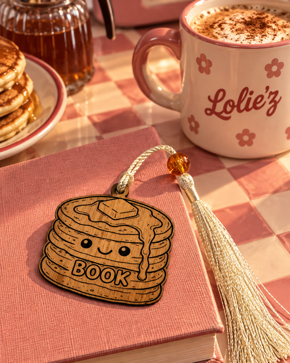 Little Pancakes, marque-page en bois gravé au laser de la collection Cuties Bakery Lolie’z, présenté sur un livre dans une ambiance gourmande avec pancakes et café.