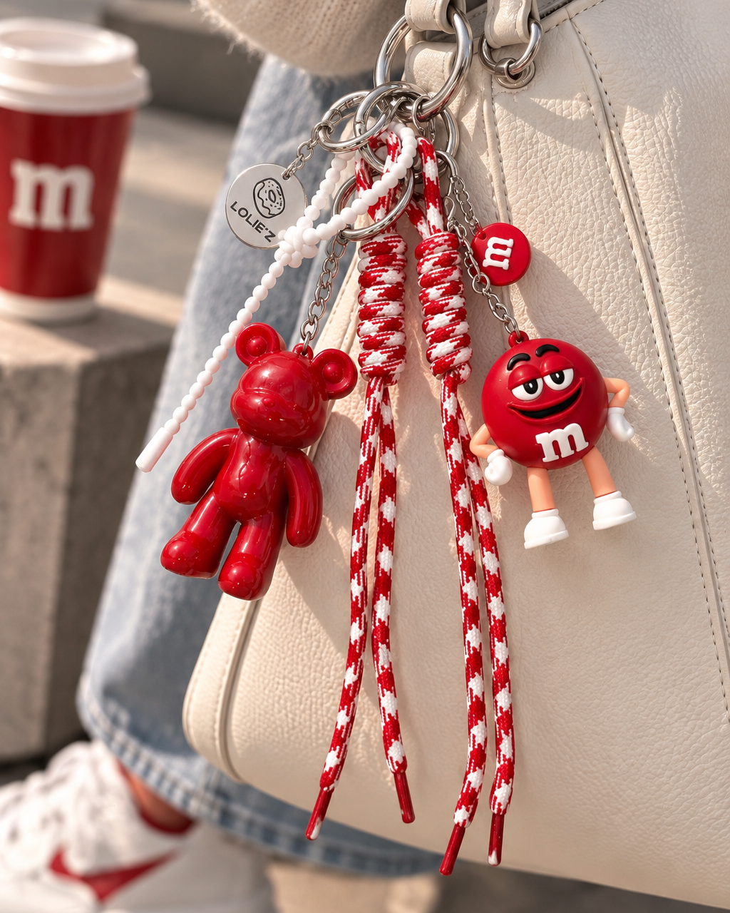 Grigri de sac rouge Lolie’z avec Teddy’z en résine époxy, cordons rouge et blanc, breloques et médaille gravée, création assemblée à la main en France.