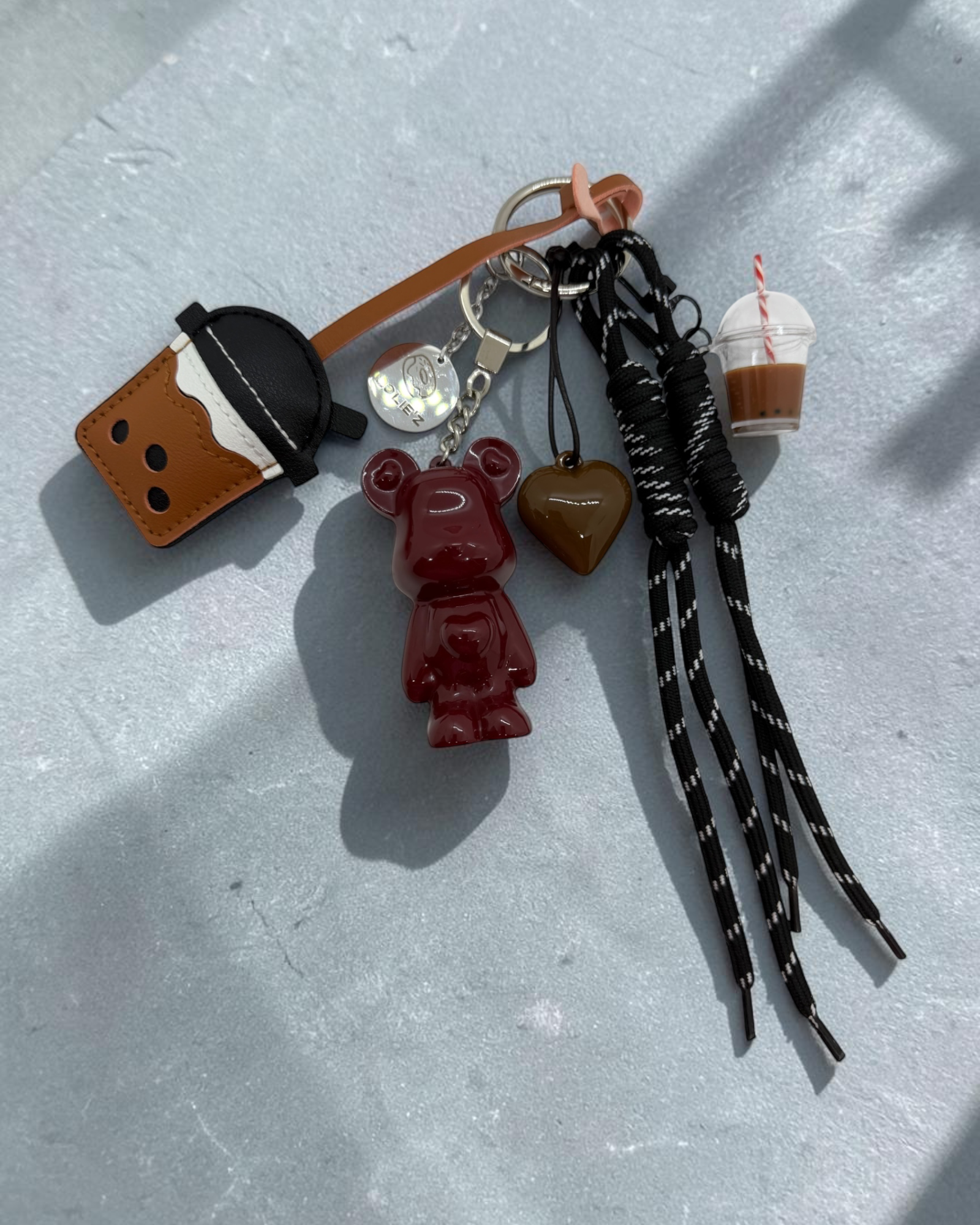 Marley Coffee First, grigri de sac rouge en résine époxy avec accessoires café, cœur chocolat et cordons noirs.