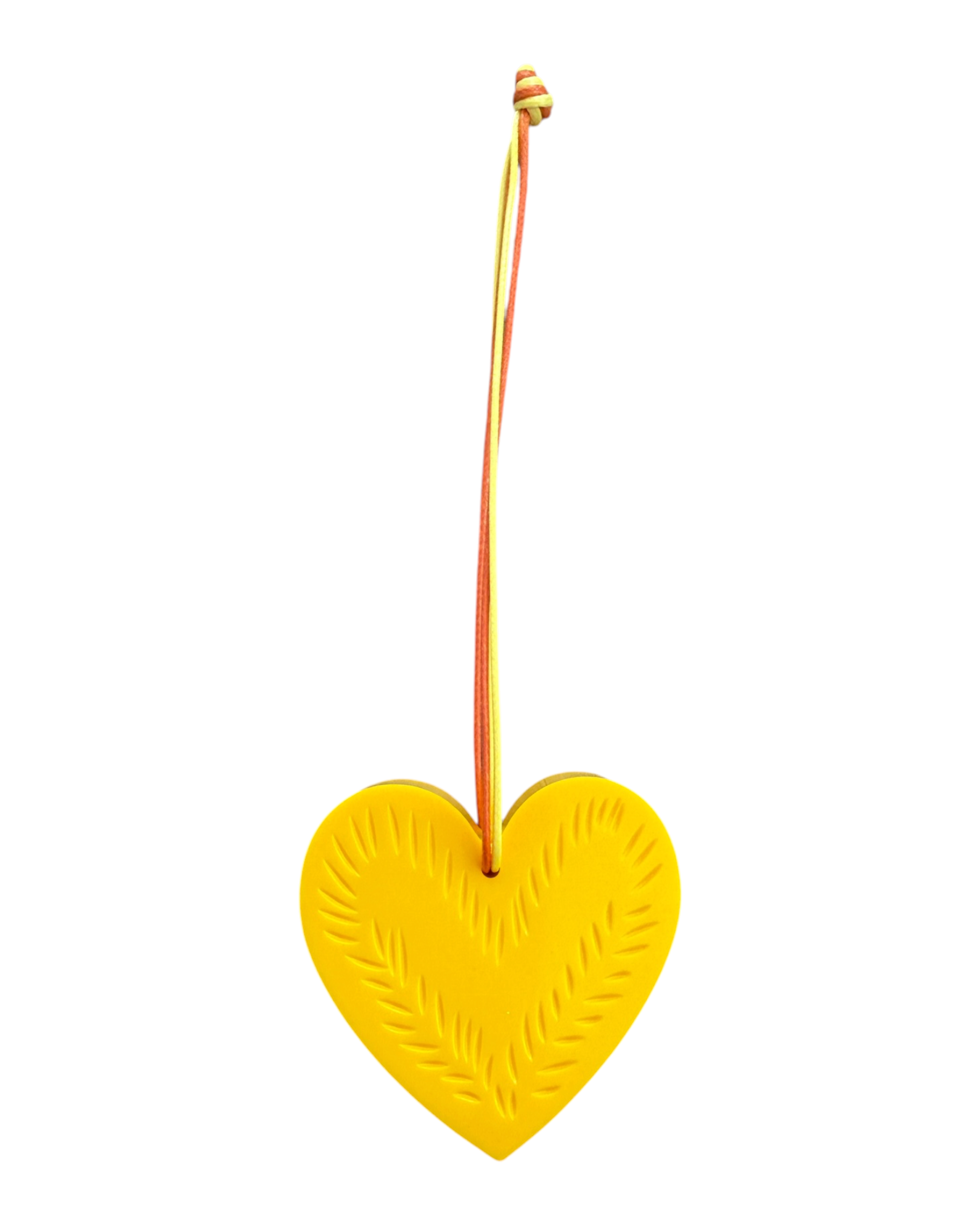 Suspension Tiny Leaf jaune en résine époxy avec cœur orné d'un décor de feuilles gravées et cordon assorti.